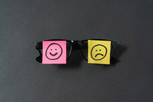 Smile and sad emoji on black background
