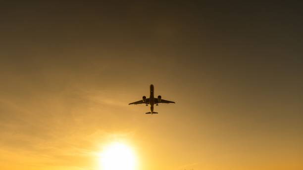 istock Bottom view of a flying plane at sunset. 2189420143
