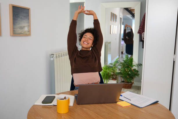 istock Young woman stretching at home office desk after work 2189420436