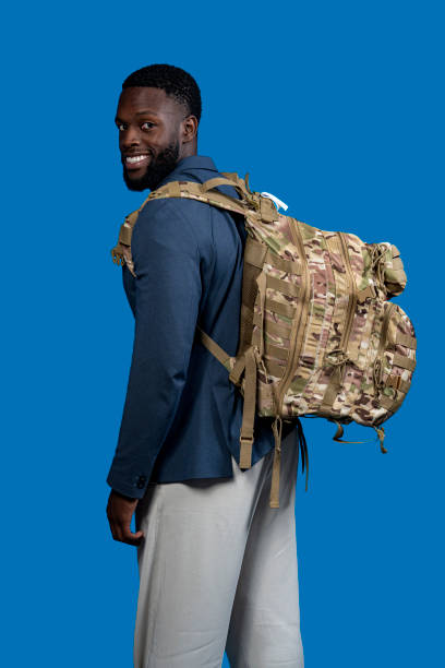 istock black man with camouflage backpack isolated on blue background 2189421575