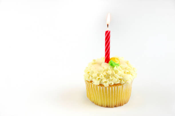 istock red candle burning on cup cake isolated on white background 2189423434
