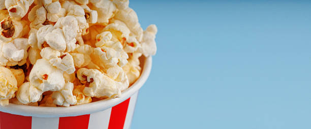 istock Classic red striped popcorn cardboard cup on blue background 2189424512