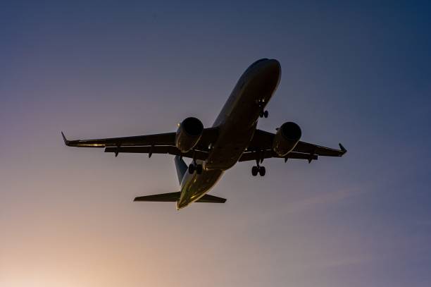 istock Bottom view of a flying plane against a blue sky. 2189426180