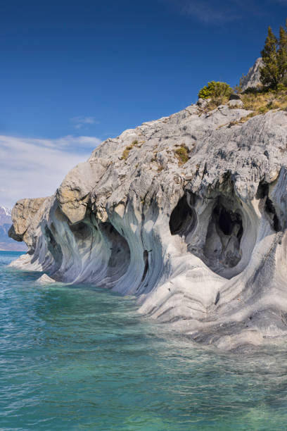 Marvel of the marble caves: a stunning view of a Cavern at the Santuario de la Naturaleza Capilla de Mármol on Lake General Carrera, Aysén, Southern Chile. The Santuario de la Naturaleza Capilla de Mármol, located on the turquoise waters of Lake General Carrera in Aysén, southern Chile, showcases nature's artistry at its finest. This breathtaking image captures the intricate details of a marble cavern, where centuries of water erosion have sculpted stunning patterns and shapes, creating a mesmerizing natural wonder. carretera austral chile stock pictures, royalty-free photos & images