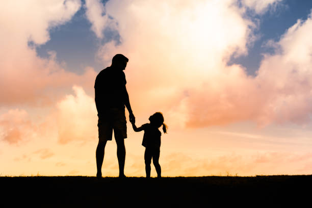 istock Father and daughter walking together at sunset. 2189430254