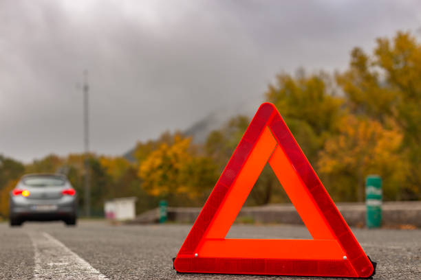 Alava province, Spanish Basque Country. Emergency triangle on a country road, indicating a car breakdown in a foggy, autumnal setting.