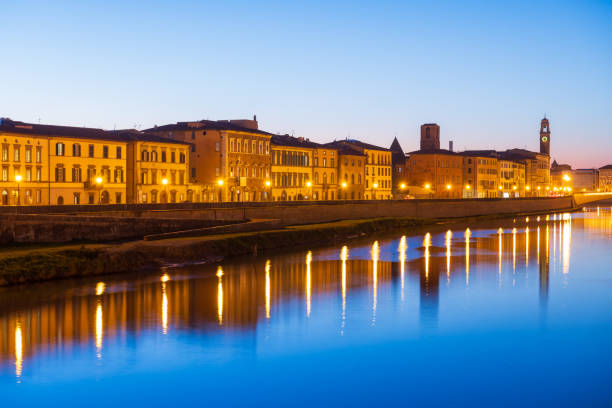 Pisa, Italy skyline on the Arno River at blue hour.