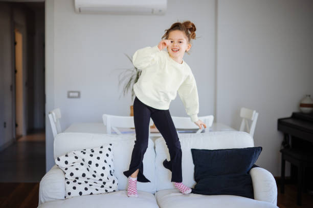 istock Happy girl jumping on the sofa 2189437271