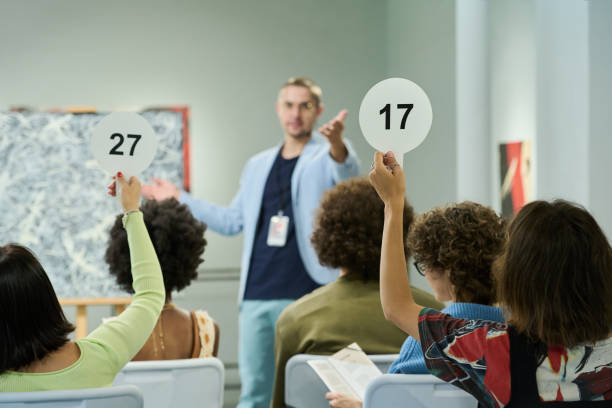 istock Auctioneers raising hands with paddles 2189437673
