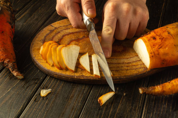 istock Skillful hands cut into a vibrant beetroot vegetable on a wooden board, showcasing the rich colors and textures as part of an inviting meal prep in a cozy kitchen setting 2189440721