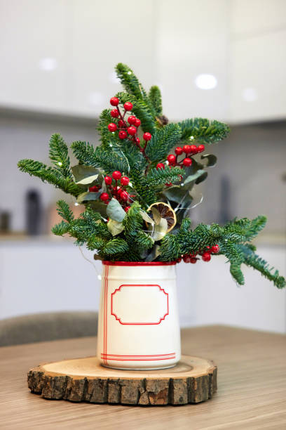 istock Fresh fir branches in ceramic vase on wooden log 2189442782
