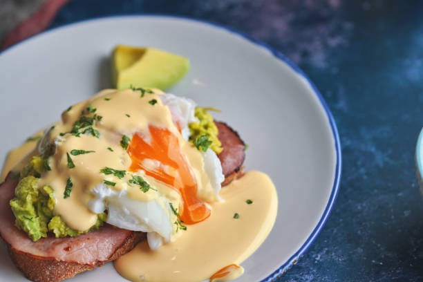 Poached Egg on Brown Bread Served with Ham, Avocado and Sauce Hollandaise