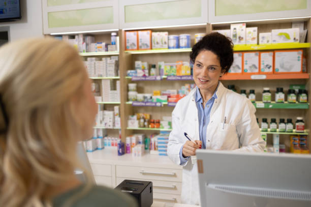 istock Female Pharmacist Assisting a Customer at a Modern Pharmacy Counter 2189444493