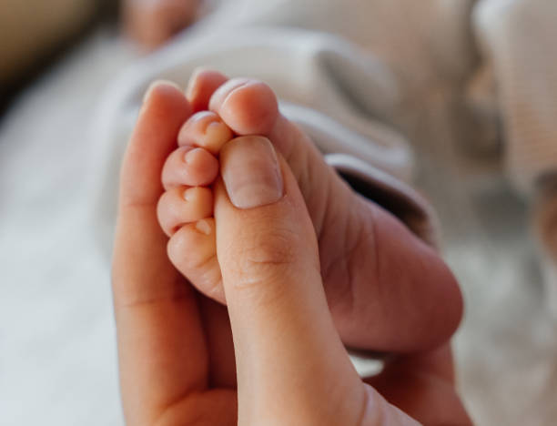 istock A newborn baby's feet in daddy's hands close-up. 2189444826
