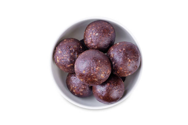 Nuts dates cocoa powder vegetarian balls in a white bowl on a white isolated background stock photo