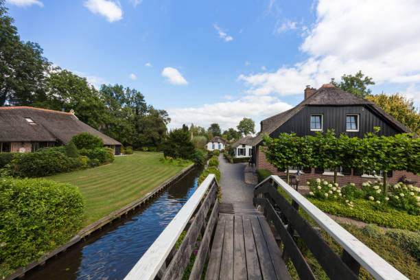 Landscape view of famous Giethoorn village with canals and rustic thatched roof houses in farm area