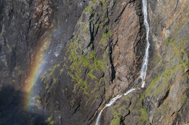 This image captures a stunning rocky cliff side with cascading waterfalls and vibrant green moss.
