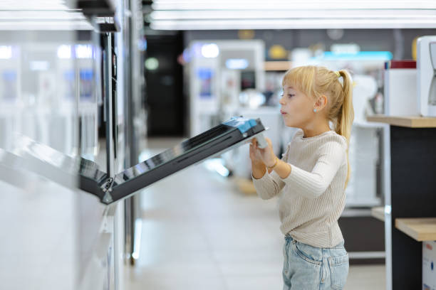 istock Young girl exploring modern ovens in an appliance store. 2189448773