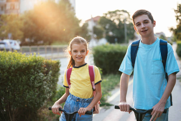 istock Smiling kids with scooters enjoy a sunny afternoon ride. 2189448980