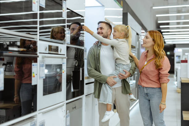 istock Happy family examining a modern oven in an electronics store 2189449121