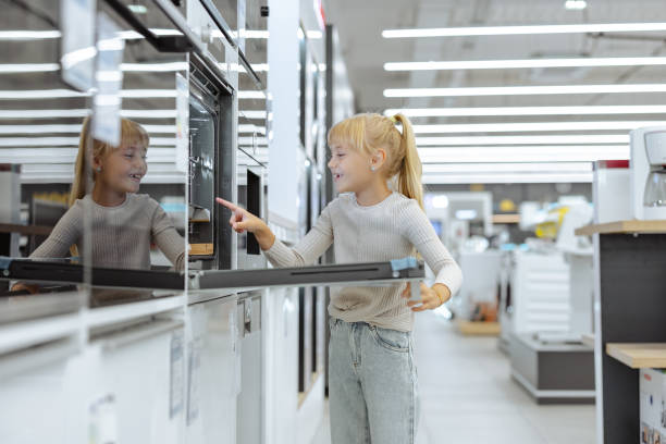 istock Young girl exploring modern appliances at a retail store 2189449157
