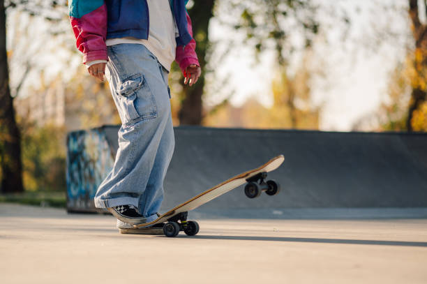 istock Skateboarder balancing on skateboard in skate park during sunset 2189450600