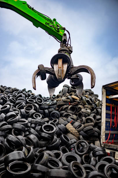 istock Industrial machine lifting and transfering used tires for recycling 2189452302