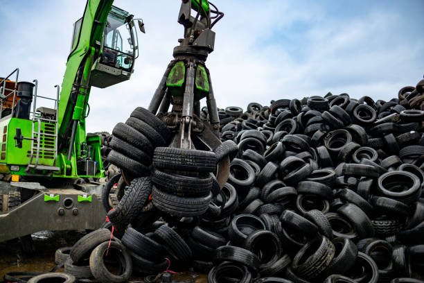 istock Machine with hook grabbing old tires at junkyard 2189452443