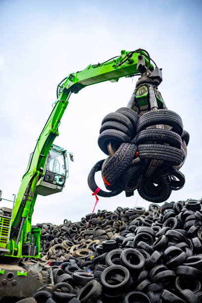 istock Machine with hook grabbing old tires at junkyard 2189452530
