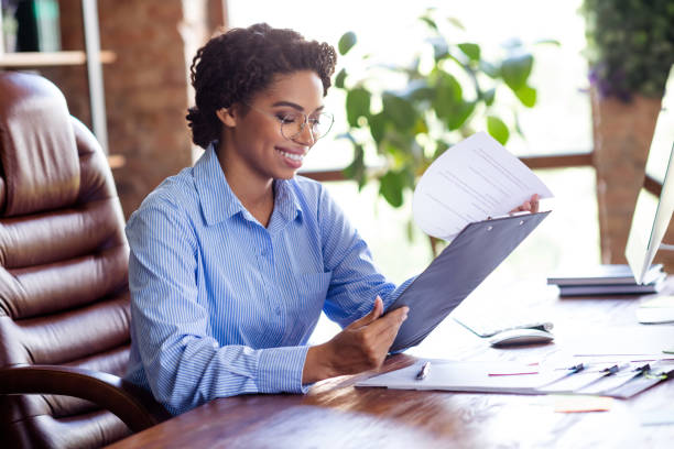 istock Confident businesswoman reviewing documents at her desk in a modern office setting, showcasing professionalism 2189453530