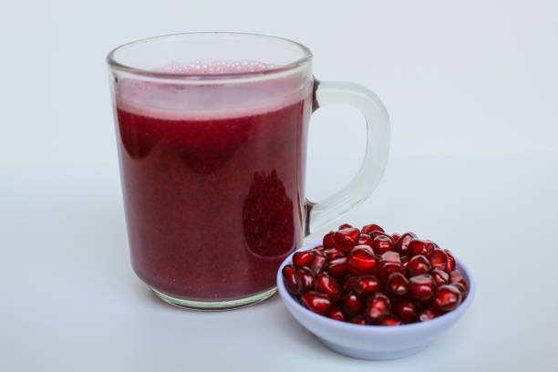 Fresh pomegranate juice, before after juicing, isolated on white background