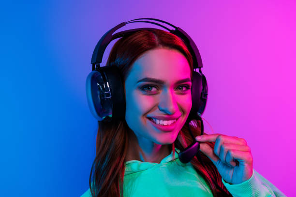 istock Photo of cheerful pretty lady dressed sweatshirt earphones talking microphone empty space isolated neon pink color background 2189462421