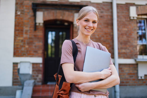 istock Smiling Student Holding Laptop Outside School Building 2189464379