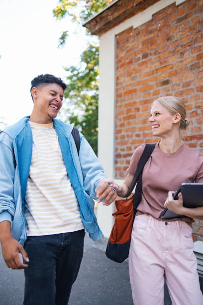 istock Happy Students Walking Together Outside a Brick Building 2189464384