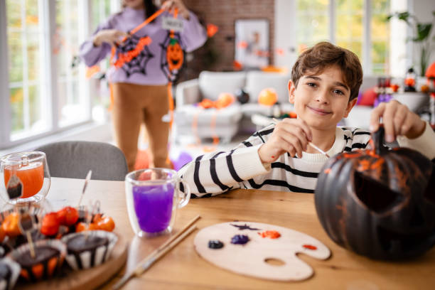 istock Child Carving Pumpkin with Halloween Decorations 2189467949