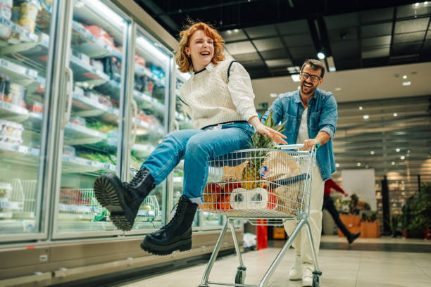 istock Playful couple having fun while shopping in supermarket 2189472073