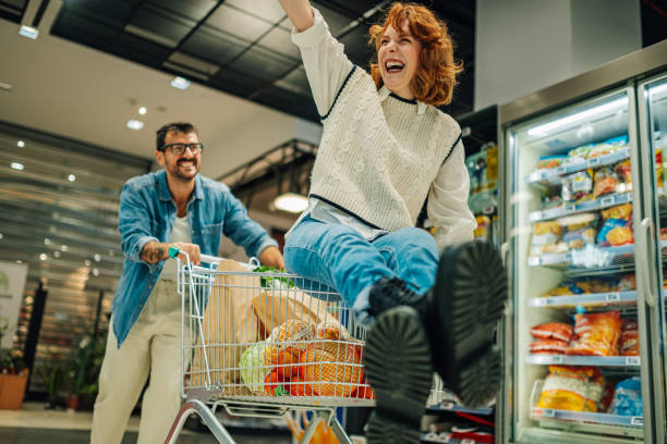 istock Playful couple having fun while grocery shopping in supermarket 2189472074