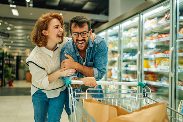 istock Cheerful couple having fun while shopping in supermarket 2189472087