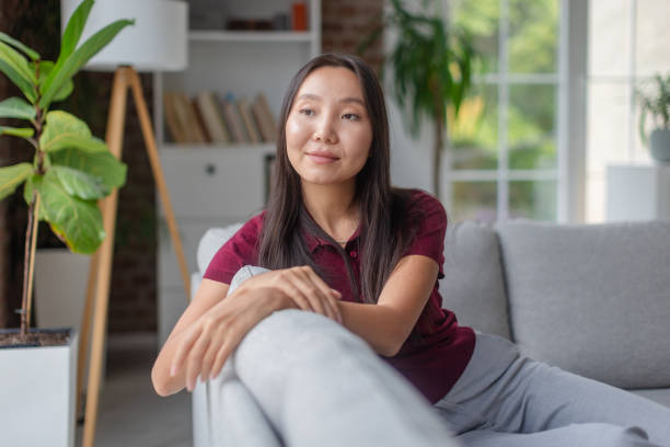 istock Woman relaxing on a sofa in a bright living room 2189476952