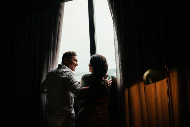istock Couple in hotel room window 2189477021