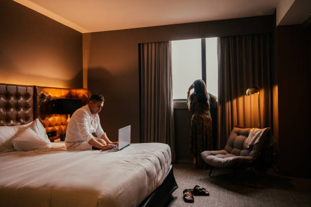 istock Man working on laptop in hotel bed 2189477123
