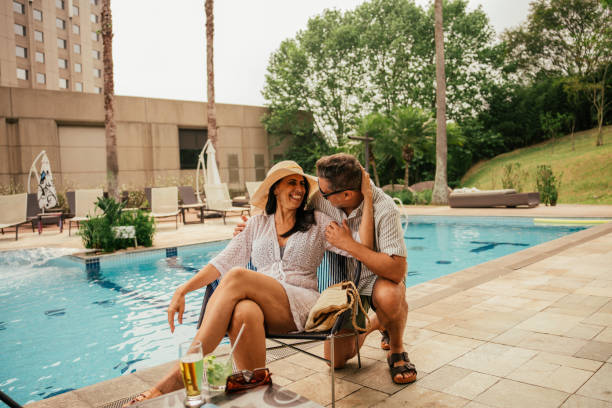 istock Couple talking by the hotel pool 2189480755