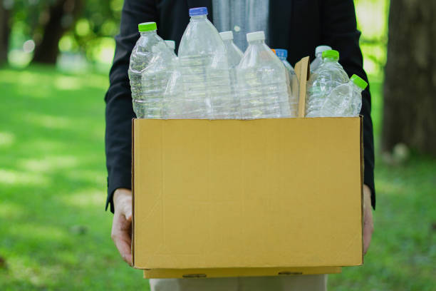 A visual representation of recycling. Recyclable items including plastic bottles, a glass bottle, paper, and batteries are shown centrally positioned inside a green recycling symbol