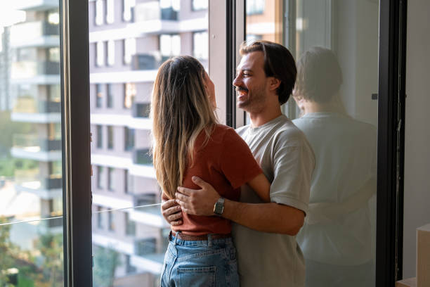istock Heterosexual couple hugging by the window 2189485028