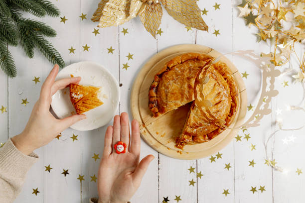 istock A woman's hands clasp a box with a royal galette and a crown on the table. 2189487524