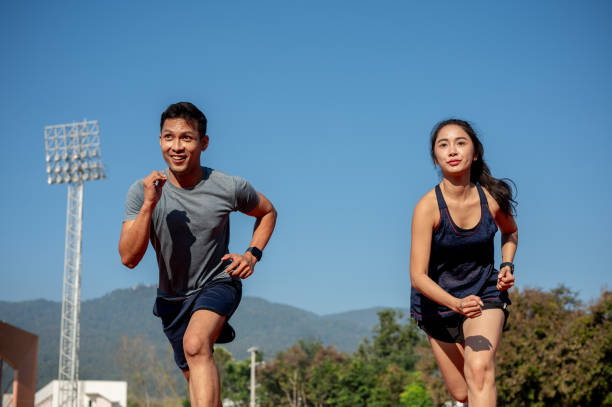 istock Two determined Asian athletes running on a track in a stadium on a sunny day. 2189491888
