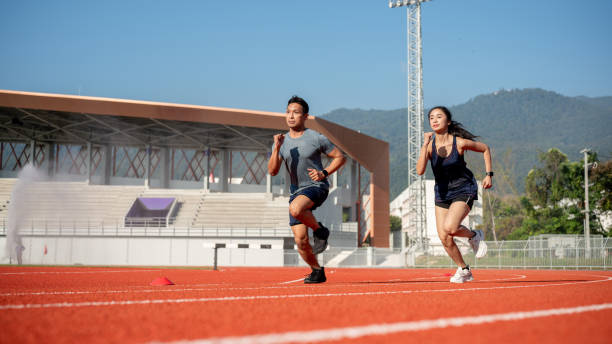 istock Two determined Asian athletes running on a track in a stadium on a sunny day. 2189491895
