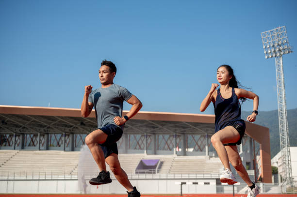 istock Two determined Asian athletes running on a track in a stadium on a sunny day. 2189491909