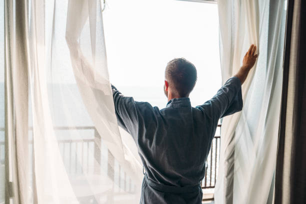 istock Man in Robe Looking Out Balcony Window 2189494284