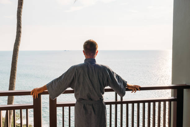 istock Man in Robe Enjoying Ocean View from Balcony 2189494347